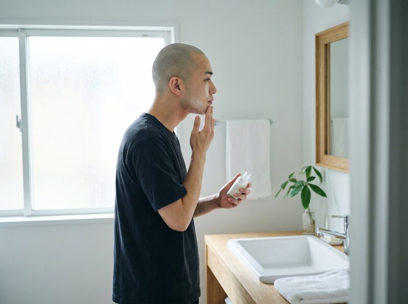 髭剃り後にスキンケアをする男性